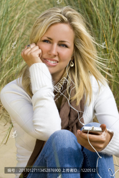 在海灘上聽音樂的女人