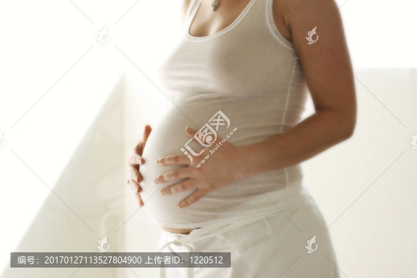 女人抱著她懷孕的肚子。