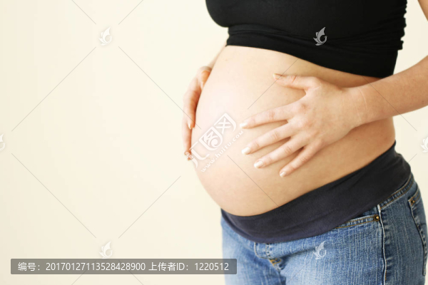 女人抱著她懷孕的肚子。
