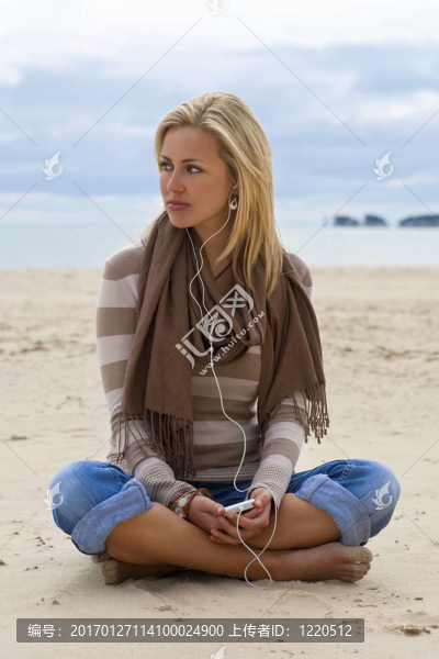 在海灘上聽音樂的女人