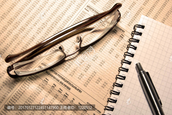 金融數(shù)字報(bào)紙上的筆和筆記本。溫暖（LBA）照片濾鏡。
