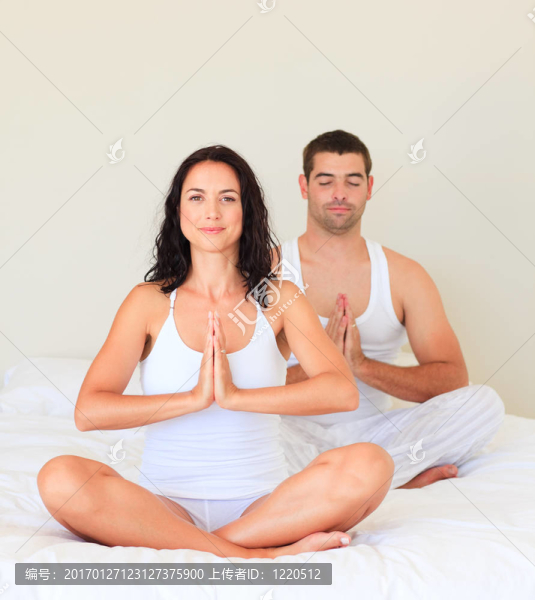 在床上做瑜伽的夫婦