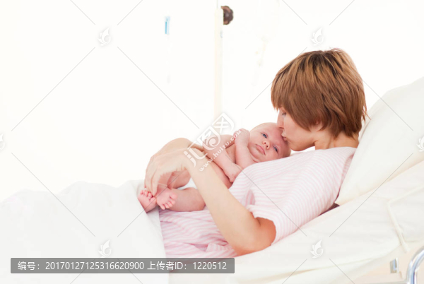母親吻她的新生嬰兒