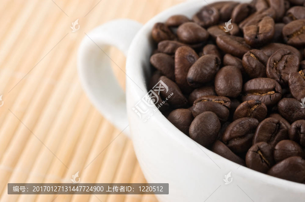 咖啡粒和杯放在竹墊