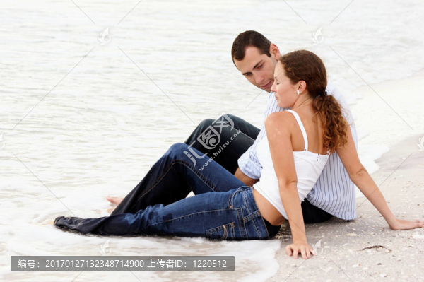 男人和女人在海灘上坐在水里