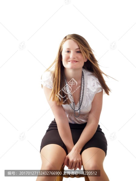 穿著黑色裙子的年輕女子坐在凳子上
