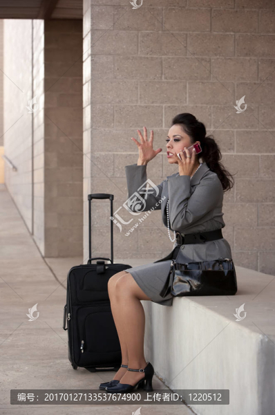 憤怒的西班牙裔女性旅行者在手機上交談