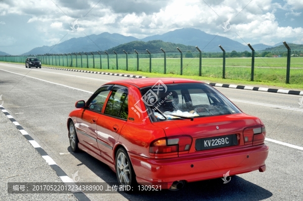 停在機(jī)場(chǎng)路旁的紅色轎車