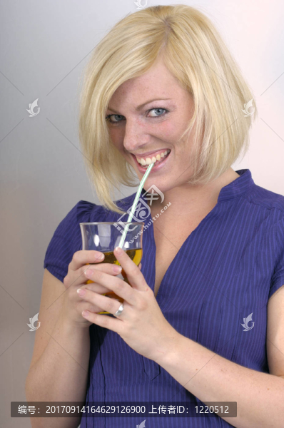 年輕女子喝一杯果汁