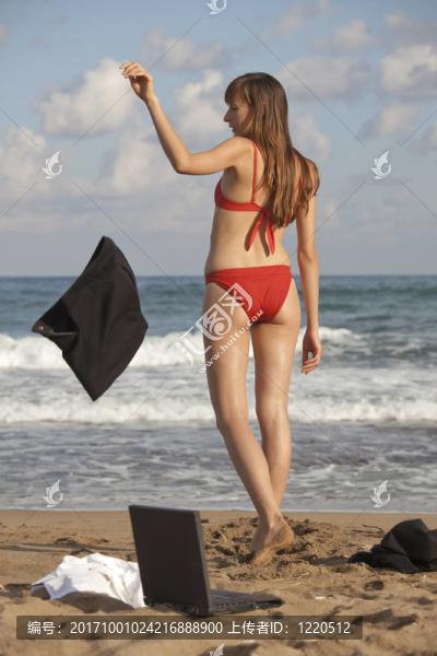 女人在海灘上扔石頭