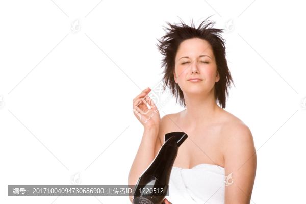 用吹風機的年輕婦女