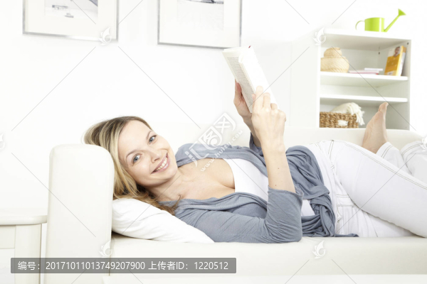 坐在沙發(fā)上看書的年輕女子