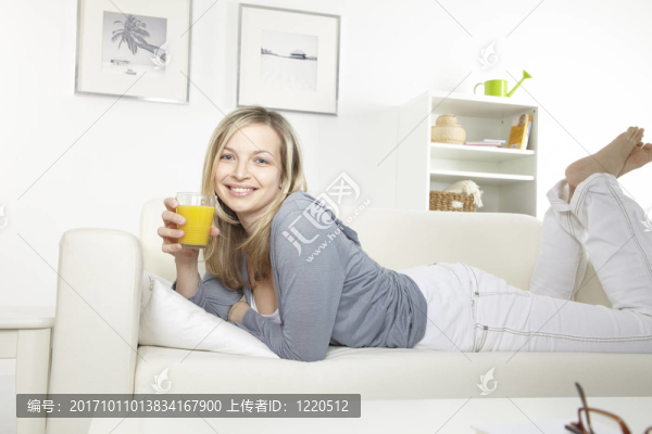 喝橙汁的年輕女子