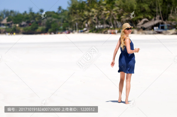 年輕女子在海灘上散步。