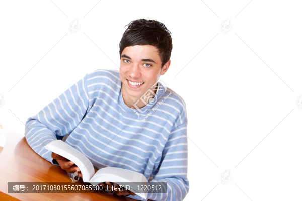 學生正坐在桌旁看書。