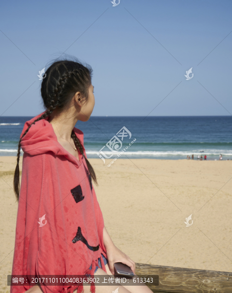 坐在海灘圍欄上的女孩