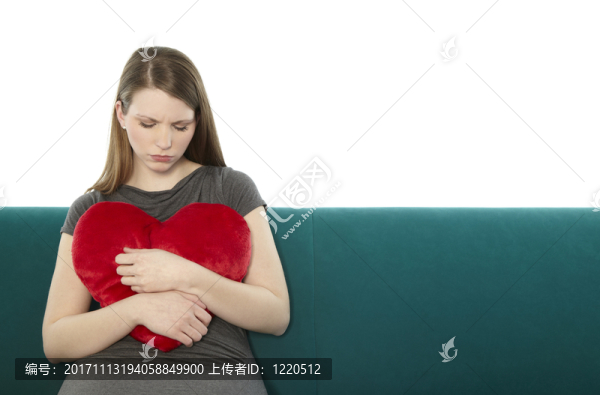 女人偎依著一顆心枕頭