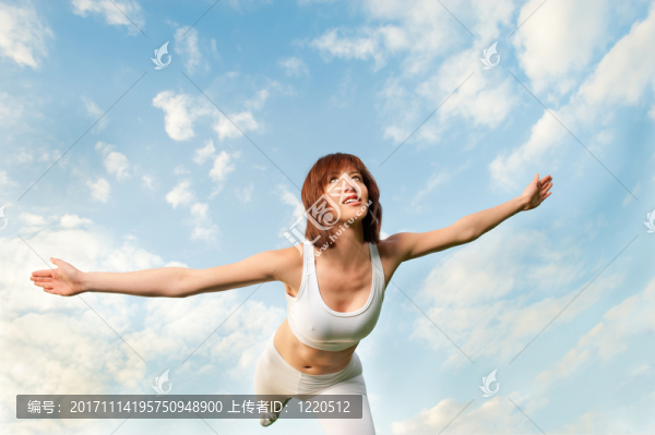 年輕的運(yùn)動(dòng)型女人平衡在藍(lán)藍(lán)的天空前