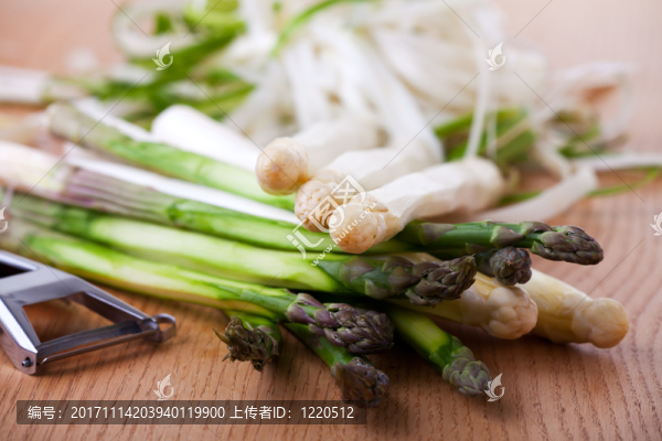 在一張橡木桌上的未加工的白色和綠色蘆筍