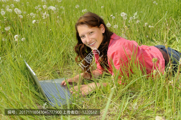 草甸與筆記本電腦上的年輕女子
