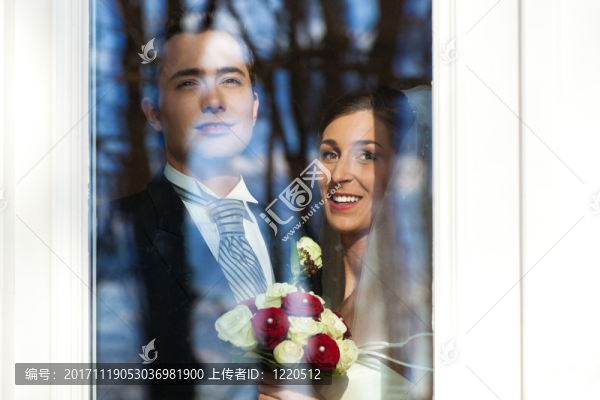 新婚夫婦在婚禮當天站在窗前