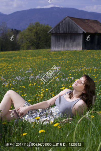 年輕女子在享受春天在草地上的衣服