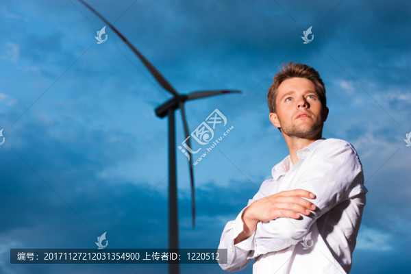 在風(fēng)力渦輪機(jī)和天空前面的人