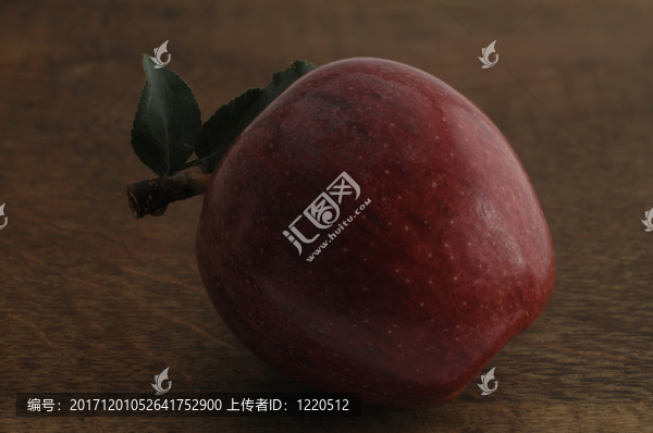 一個紅蘋果與葉在木板上