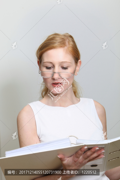 辦公室里的年輕女子在她的文件中看起來