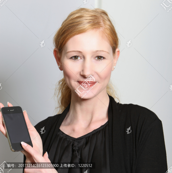年輕，微笑的女人提出了他們的智能手機(jī)