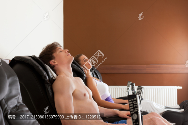 夫婦在健身房的按摩椅上
