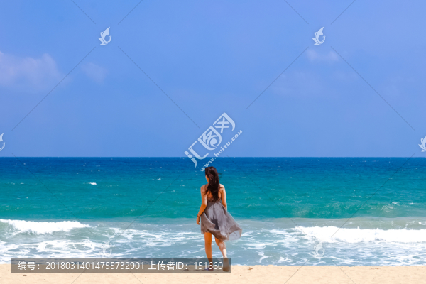 沙灘上面朝大海的女人背影