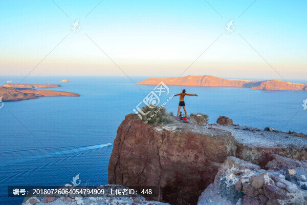 希臘圣托里尼島站在懸崖上的人