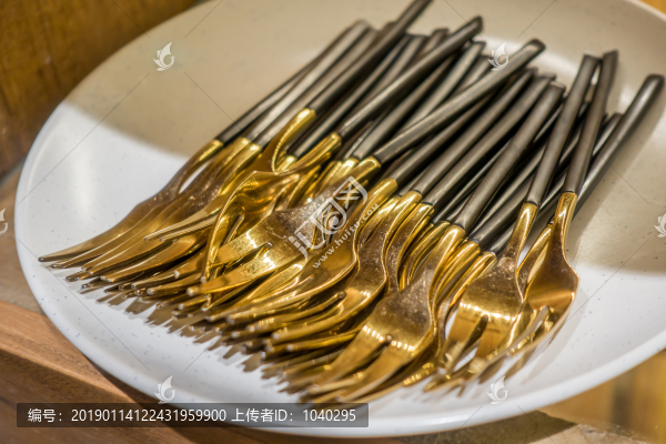 放在碟子里的許多金屬制餐具勺子