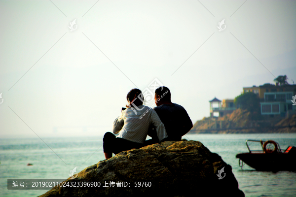 坐在礁石上的游客