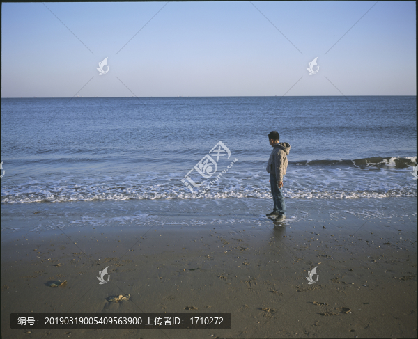 海邊站立的小男孩
