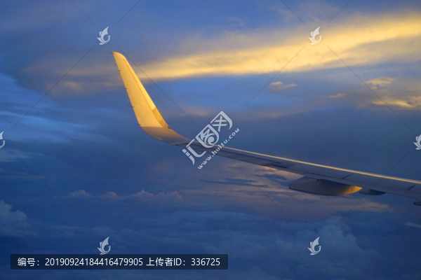 在晚霞中飛行的飛機機翼