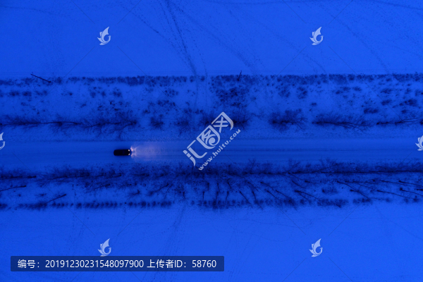 一輛越野車在雪原夜色道路上行駛
