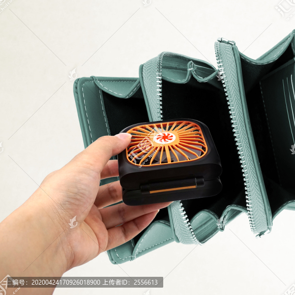 拿小電扇放入包包的動作