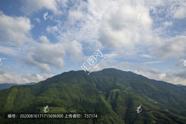 藍(lán)天白云下映襯下的綠色山峰