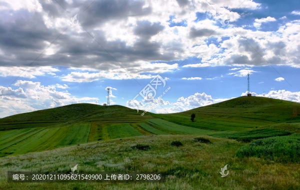 藍(lán)天白云下山丘上鐵塔和農(nóng)田