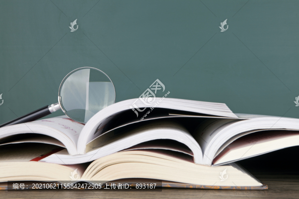 一堆翻開(kāi)的書籍和放大鏡