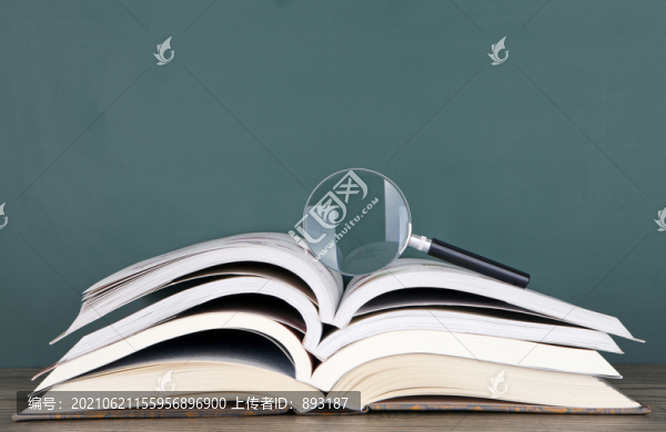 一摞書和上面的放大鏡