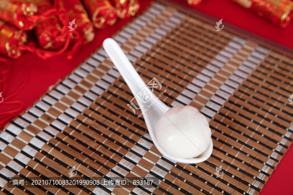 竹墊子上的勺子和勺子里的湯圓