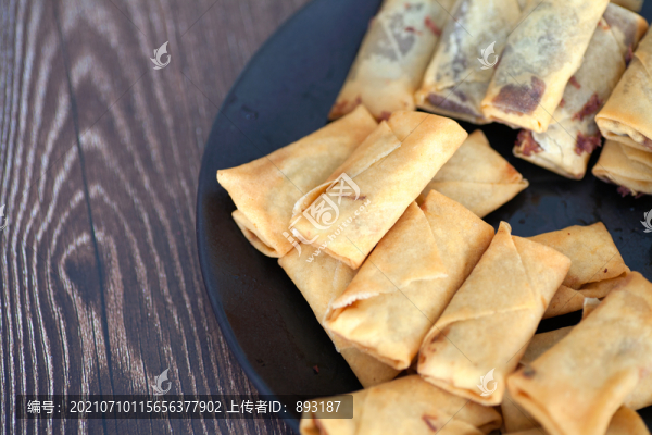 俯視桌子上盤子里金黃色的春卷