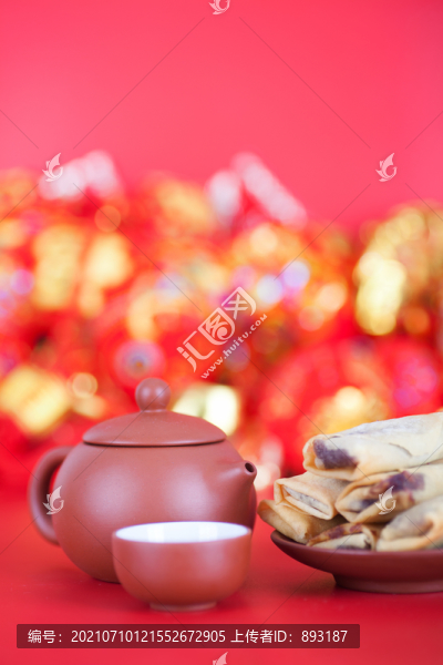 紅背景上一盤立春的炸春卷和茶壺