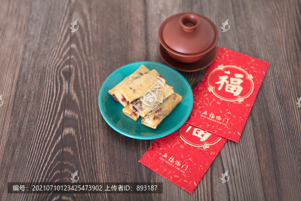 桌子上的炸春卷和茶及紅包