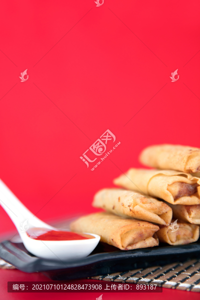 紅背景上的油炸春卷和蘸料