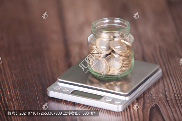 電子秤上一個(gè)盛滿歐元硬幣的玻璃