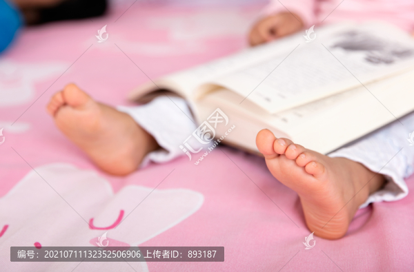 特寫把書本攤在腿上看書的小孩子